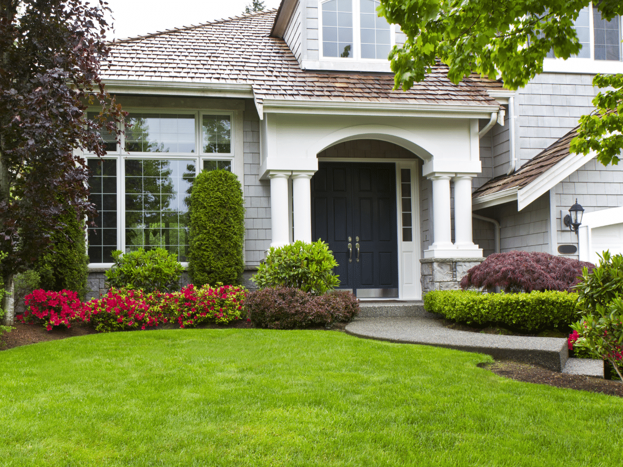 Front Yard with Beautiful House and Colored Flowers on Bushes